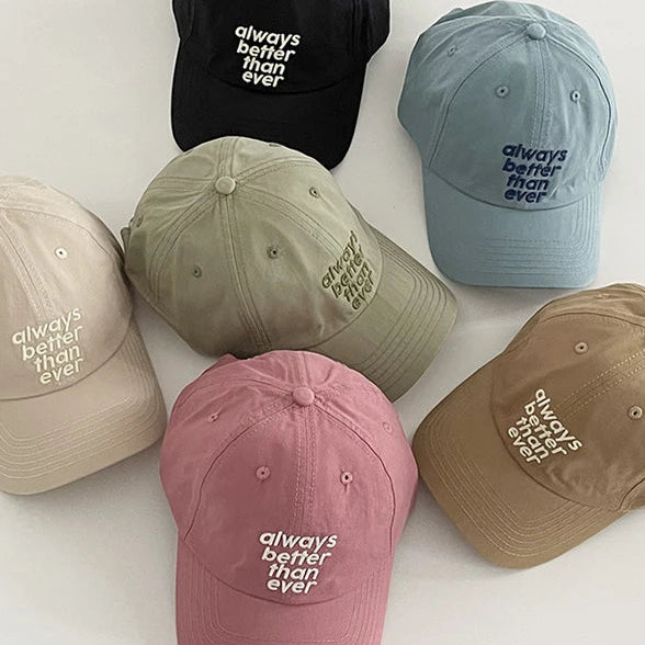 Collection of colorful baseball caps with "Always Better Than Ever" text on a white background