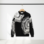 Black sweater with abstract white pattern on a rack against a white background