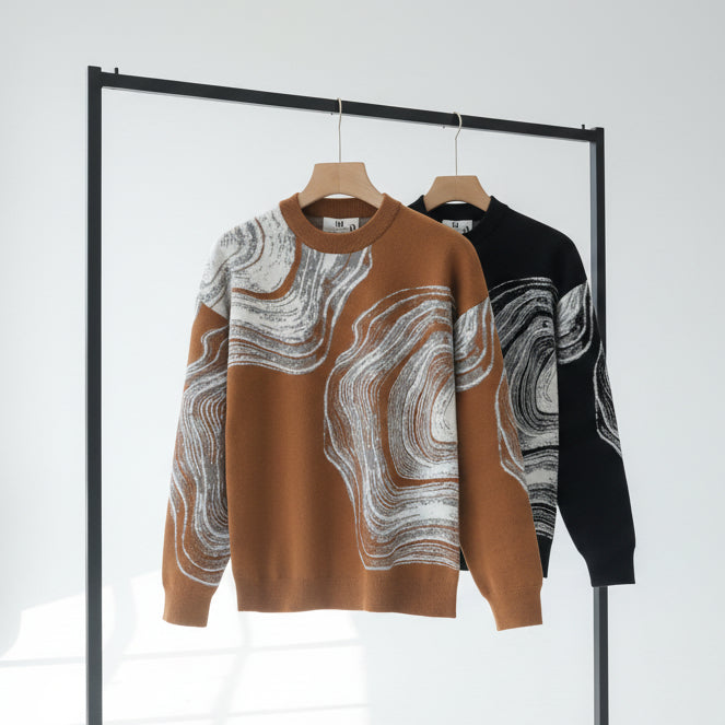 Ochre & black sweater with abstract pattern on a rack against a white background.