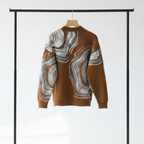 Back of the Ochre sweater with white abstract pattern on a hanger against a white background.