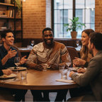 Male model wearing the Ochre sweater with a group of friends enjoying a meal together at a restaurant.