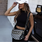 Woman wearing a black crop top, white cap, and black and white checkered Baye Bag in an urban setting.