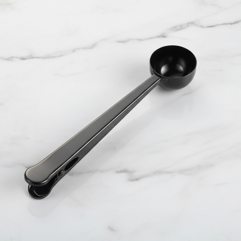 Black measuring spoon on a white marble surface