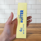 Hand holding a 4oz squishy sensory block of butter. 