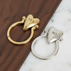 Gold and silver heart-shaped keychains with 'NO' and 'YES'.