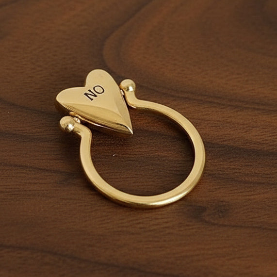 Gold heart-shaped ring on a walnut wood surface.