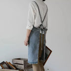 Person wearing a denim apron in a minimalistic setting