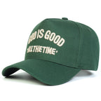 Green cap with 'God is Good All the Time' text on a white background