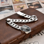 Silver chain bracelet with a detailed clasp on a textured surface
