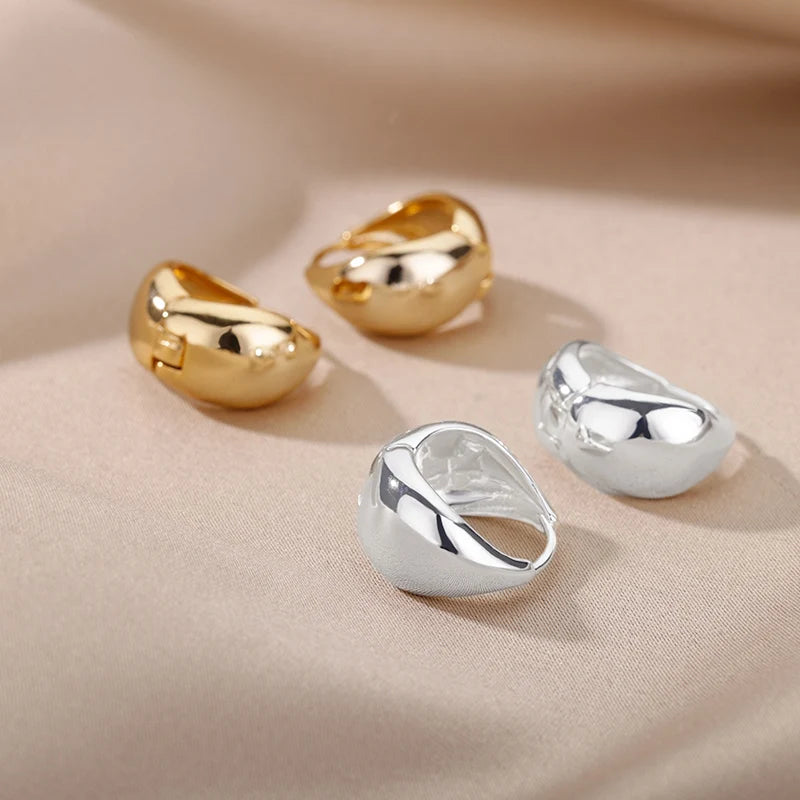 Three rings in gold and silver on a beige fabric background