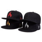 Four black caps with different symbol designs on a white background