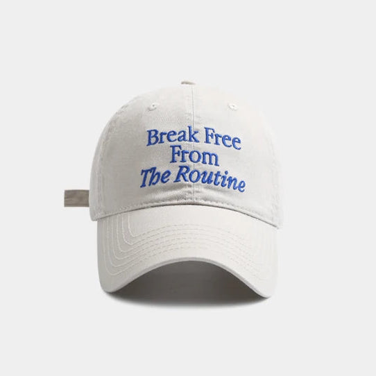White cap with blue text 'Break Free From The Routine' on a white background.