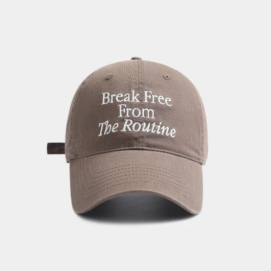 Taupe cap with 'Break Free From The Routine' text on a white background.