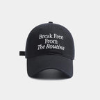Black cap with white text 'Break Free From The Routine' on a light gray background.