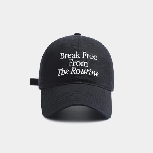 Black cap with white text 'Break Free From The Routine' on a light gray background.