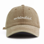 Beige cap with 'overstimulated' text on a white background
