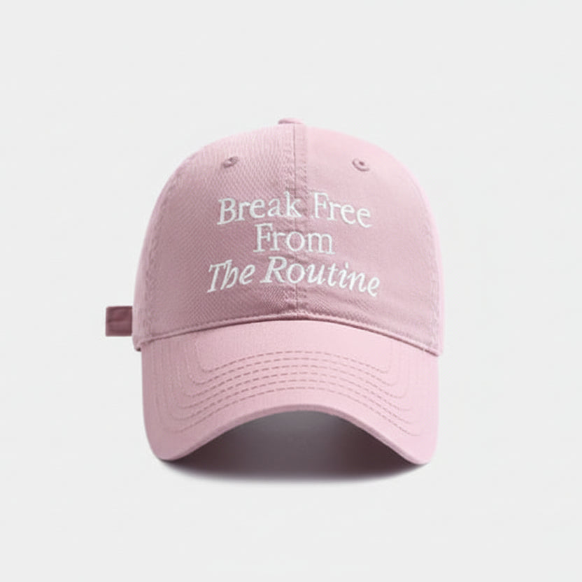 Pink Break Free From The Routine baseball cap with text on a light gray background.