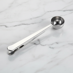 Silver measuring scoop on a marble surface.