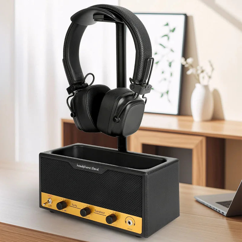 Black and yellow headphone stand with a pair of headphones on a desk.