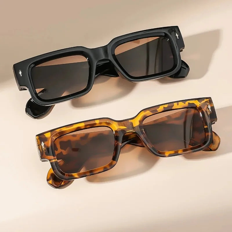 Two pairs of sunglasses, one black and one tortoiseshell, on a beige background.