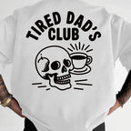 White t-shirt with 'Tired Dad's Club' graphic and skull design on a plain background